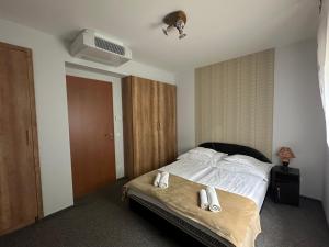 a bedroom with a bed with two towels on it at Családi Villa in Balatonszemes +22 photos