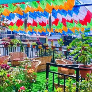 einen Balkon mit bunten Sonnenschirmen und Pflanzen in der Unterkunft Yog Hostel in Kathmandu
