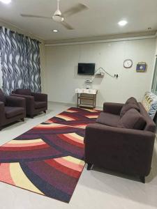 a living room with two couches and a rug at Homestay Sejati in Kuala Berang