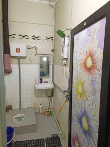 a bathroom with a shower with flowers painted on the wall at Homestay Sejati in Kuala Berang