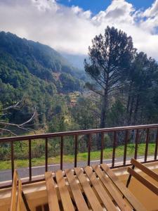un banco de madera en un balcón con vistas a la montaña en Asomadilla by #cherrygredos, en El Arenal