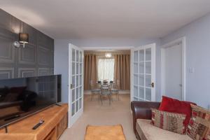 a living room with a couch and a television at Leed City Centre - Armley Wortley in Leeds