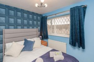 a bedroom with a bed with blue walls and a window at Leed City Centre - Armley Wortley in Leeds