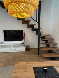 a living room with a television and a staircase at Kasi Polany in Krempna