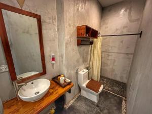 a bathroom with a sink and a toilet and a mirror at Hostel by Monsoon Riverside in Phnom Penh