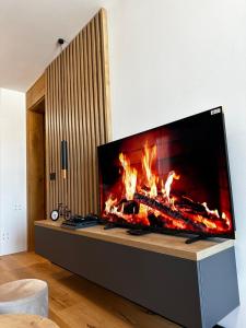 a fireplace in a living room with a fire in it at Apartment Aurora in Bjelašnica