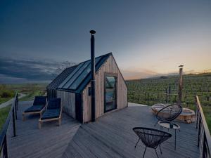 a small wooden house with chairs on a deck at CAMPY ECO HOUSE • EGER in Egerszólát