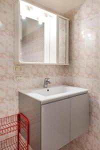 uma casa de banho com um lavatório branco e um espelho. em M355 - Marcelli, bilocale con giardino e parcheggio em Marcelli
