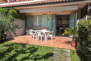 a patio with a white table and chairs on it at M355 - Marcelli, bilocale con giardino e parcheggio in Marcelli