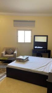 a bedroom with a bed and a couch and a television at شقق العاصفه4 in Khamis Mushayt