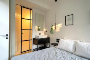 a bedroom with a white bed and a sink at Hoppersgr- Amazing apt in the heart of Athens - 5 in Athens