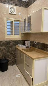 a kitchen with white cabinets and a counter top at شقق العاصفه4 in Khamis Mushayt
