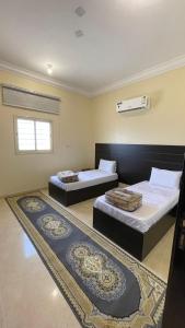 two beds in a room with two rugs at شقق العاصفه4 in Khamis Mushayt