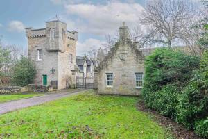 an old stone house with a gate in a yard at The Gate House - 3 Bed & Parking in Edinburgh