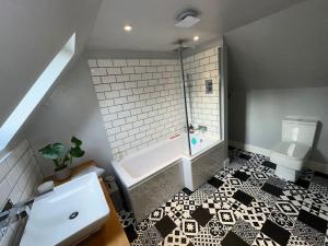 La salle de bains est pourvue d'une baignoire et de toilettes. dans l'établissement The Gate House - 3 Bed & Parking, à Édimbourg