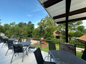 eine Terrasse mit Tischen und Stühlen sowie einem Spielplatz in der Unterkunft Családi Villa in Balatonszemes