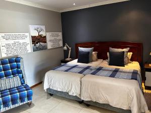 1 dormitorio con 1 cama y 1 silla azul en Meyers Guesthouse, en Jwaneng