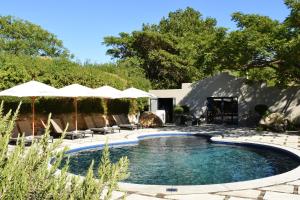 een zwembad met stoelen en parasols in een tuin bij The Jordan Suites in Stellenbosch