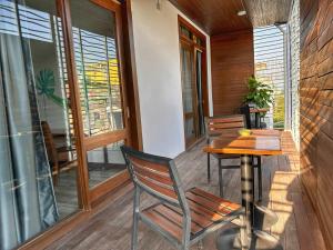 a porch with a wooden table and chairs on a balcony at Hostel by Monsoon Riverside in Phnom Penh +31 photos