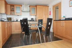 uma cozinha com uma mesa e cadeiras pretas em Bournecoast: Two bedroom flat with stunning panoramic views - FM2775 em Bournemouth