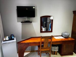 a wooden desk with a mirror and a television on a wall at Meyers Guesthouse in Jwaneng