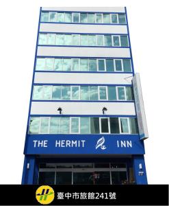 a tall building with a sign for the hermit inn at Hermit Crab B&B in Wuqi