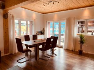 - une salle à manger avec une table et des chaises dans l'établissement Al Porto Fantastic Lake & Mountain View Apartment, à Brienz