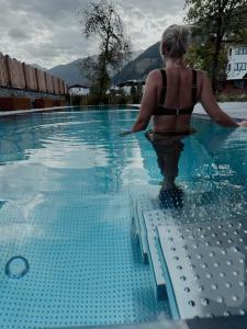 een vrouw in bikini die in een zwembad staat bij Alpine Lofts M26 in Grossarl