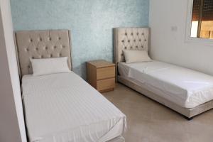 2 Betten nebeneinander in einem Zimmer in der Unterkunft Luxury Apartment II Nador Jadid Free Parking & Wifi in Nador