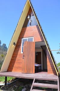 una casa con techo triangular y puerta grande en Dollies Mountain View en Kodaikānāl