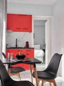 una cucina con armadi rossi, tavolo e sedie di Athens Project Luxury Apartments ad Atene