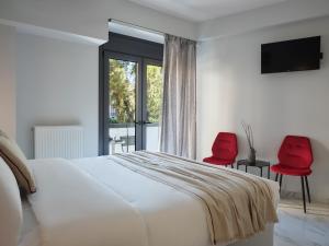 a bedroom with a bed and two red chairs at Athens Project Luxury Apartments in Athens