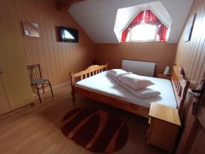 a bedroom with a bed with white sheets and a window at Casa Corina Sirnea in Şirnea