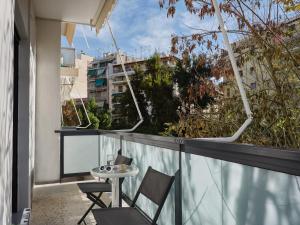 a balcony with two chairs and a table on a building at Athens Project Luxury Apartments in Athens