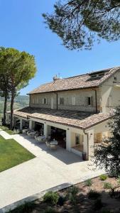 un gran edificio con sillas y mesas delante de él en Colle Serrano Relais & SPA, en Ripatransone