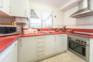 a kitchen with white cabinets and a red counter top at Charming Villa in Lliria w/ Private Pool & Garden in Lliria