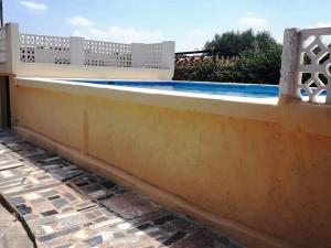 uma piscina amarela com uma cerca branca à volta em Charming Villa in Lliria w/ Private Pool & Garden em Lliria