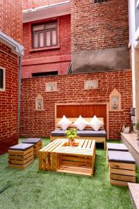 um pátio com um sofá e uma mesa em frente a um edifício de tijolos em Nyadha House Bed & Breakfast em Patan