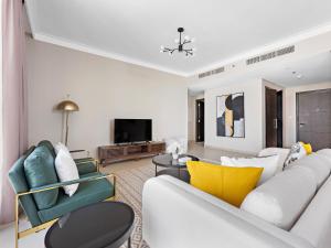 a living room with a white couch and chairs at Brand New Spacious 2BDR Dubai Creek Residences - South in Dubai