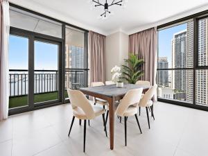 a dining room with a table and chairs and large windows at Brand New Spacious 2BDR Dubai Creek Residences - South in Dubai