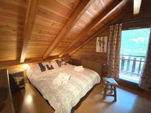 - une chambre avec un lit et une grande fenêtre dans l'établissement LE MONTAGNARD Chalet en bois, à La Bresse
