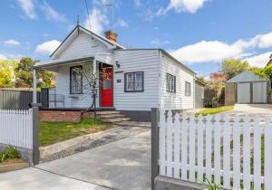 a white house with a white picket fence at Antique Retreat in Bathurst +6 photos
