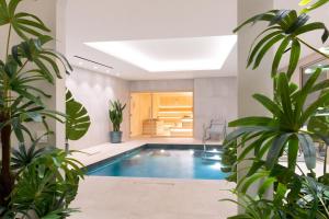 a swimming pool in a room with plants at Hôtel Golf & Spa Château de la Bégude The Originals Collection in Valbonne