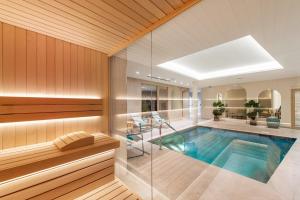 een zwembad in een huis met een bad bij Hôtel Golf & Spa Château de la Bégude The Originals Collection in Valbonne