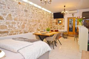a dining room with a table and a stone wall at Apartment Michaela 4-Sterne & Parking in Rovinj