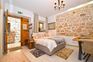 a bedroom with a bed and a stone wall at Apartment Michaela 4-Sterne & Parking in Rovinj