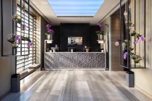 una hall di un hotel con fiori sul muro di Starhotels Echo a Milano