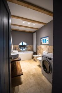 a bathroom with a tub sink and a washing machine at Guesthouse 340 in Roman