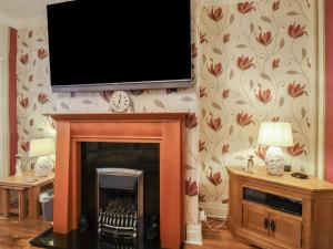 a living room with a fireplace and a flat screen tv at 19 Slinger Road in Cleveleys