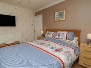 a bedroom with a bed and a flat screen tv at 19 Slinger Road in Cleveleys